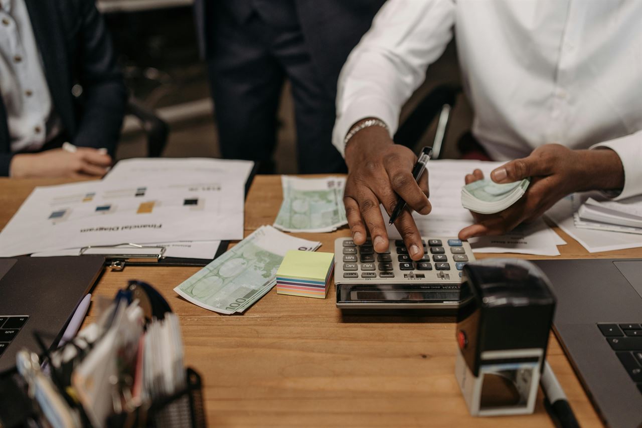 Gestion manuelle d'un petit commerce — calculatrice, argent et paperasse